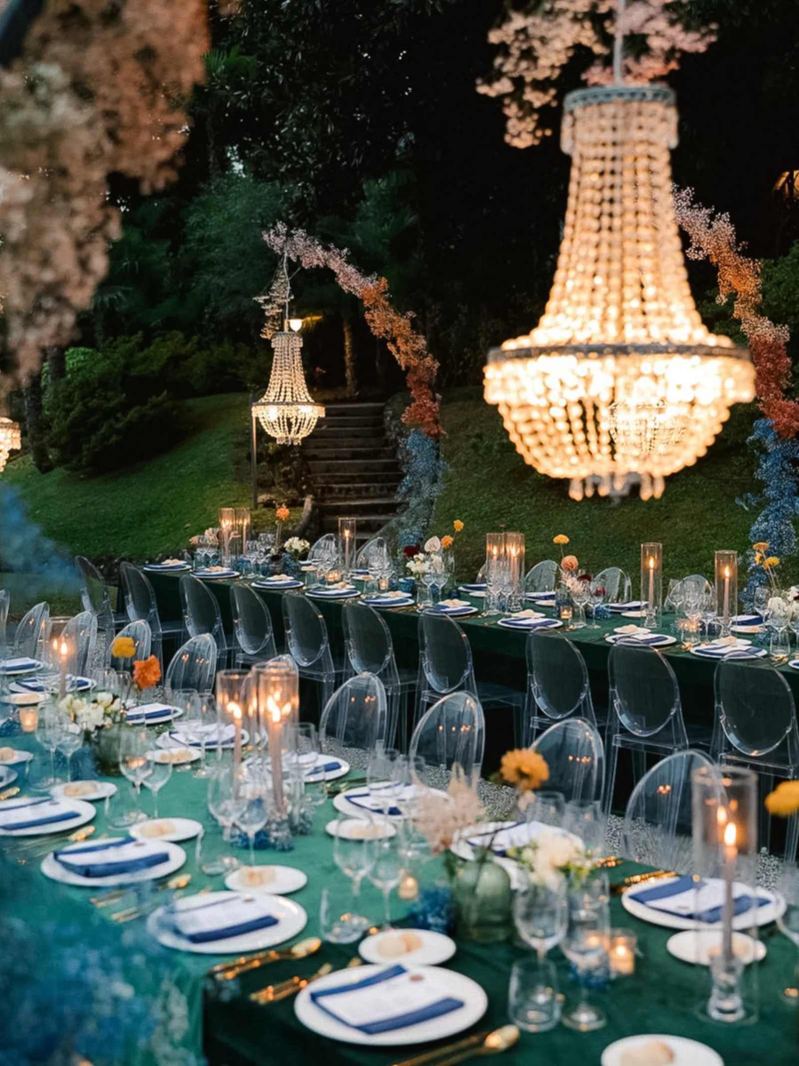 Festlich gedeckte Hochzeitstafel im Villengarten am Comer See, beleuchtet von Kristall-Kronleuchtern