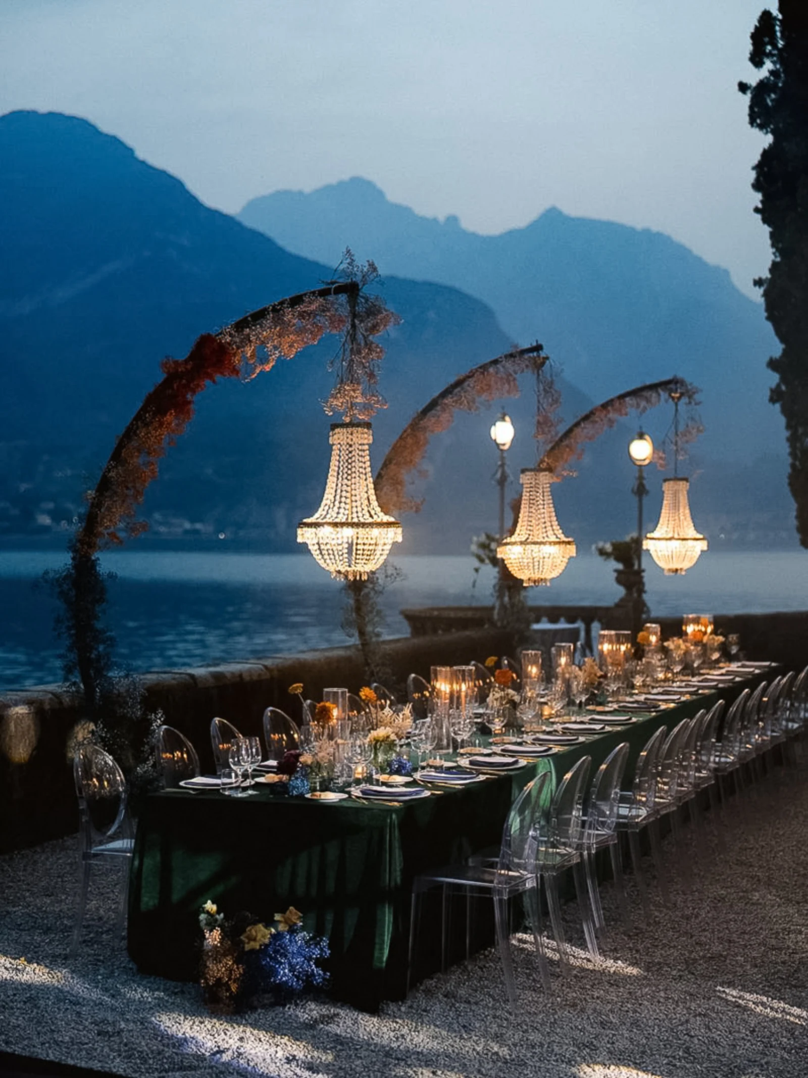 Lange Hochzeitstafel auf einer Terrasse mit Seeblick in Italien, abendlich beleuchtet