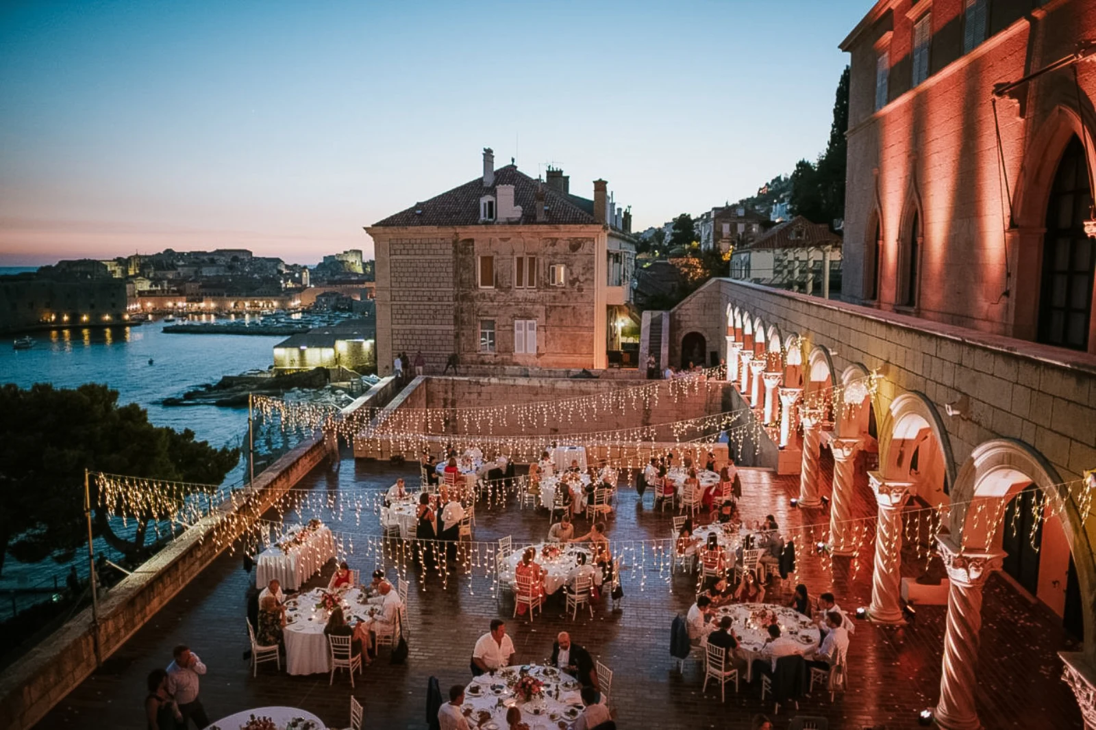 Abendliche Hochzeitsfeier auf einer Steinterrasse mit Blick auf die beleuchtete Altstadt von Dubrovnik