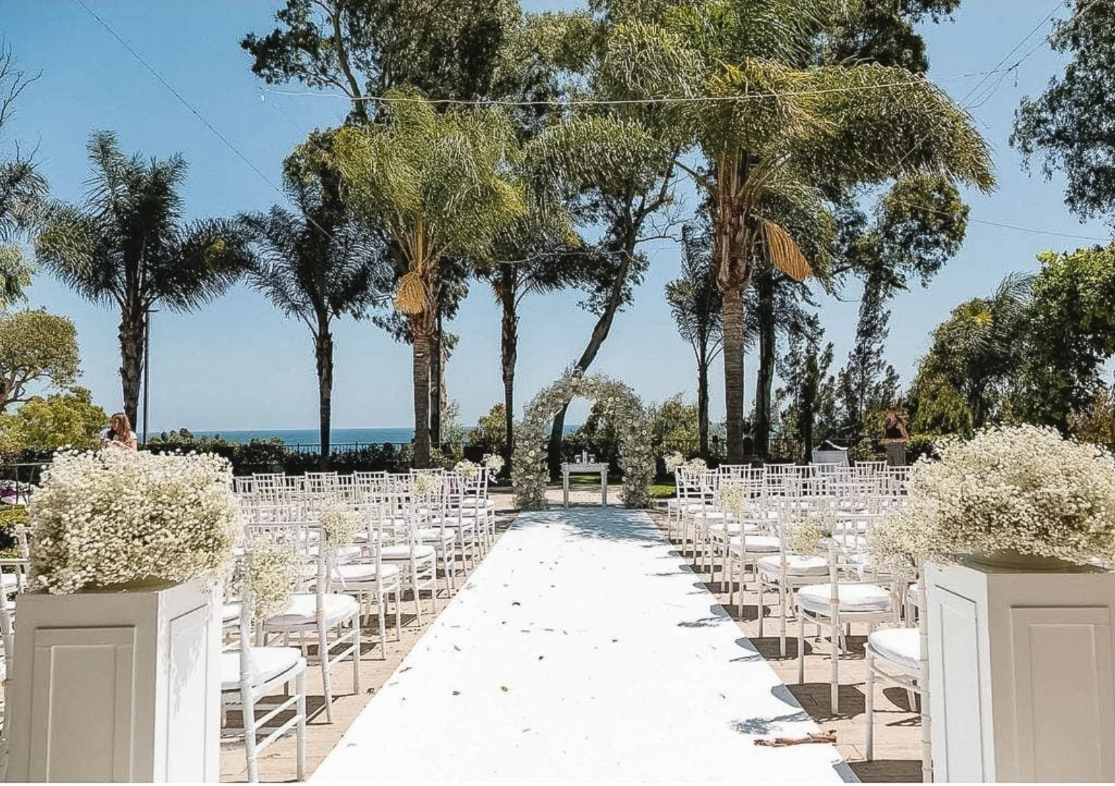 Freie Trauung im Finca-Garten auf Mallorca, weißer Gang mit Blumen und Meerblick