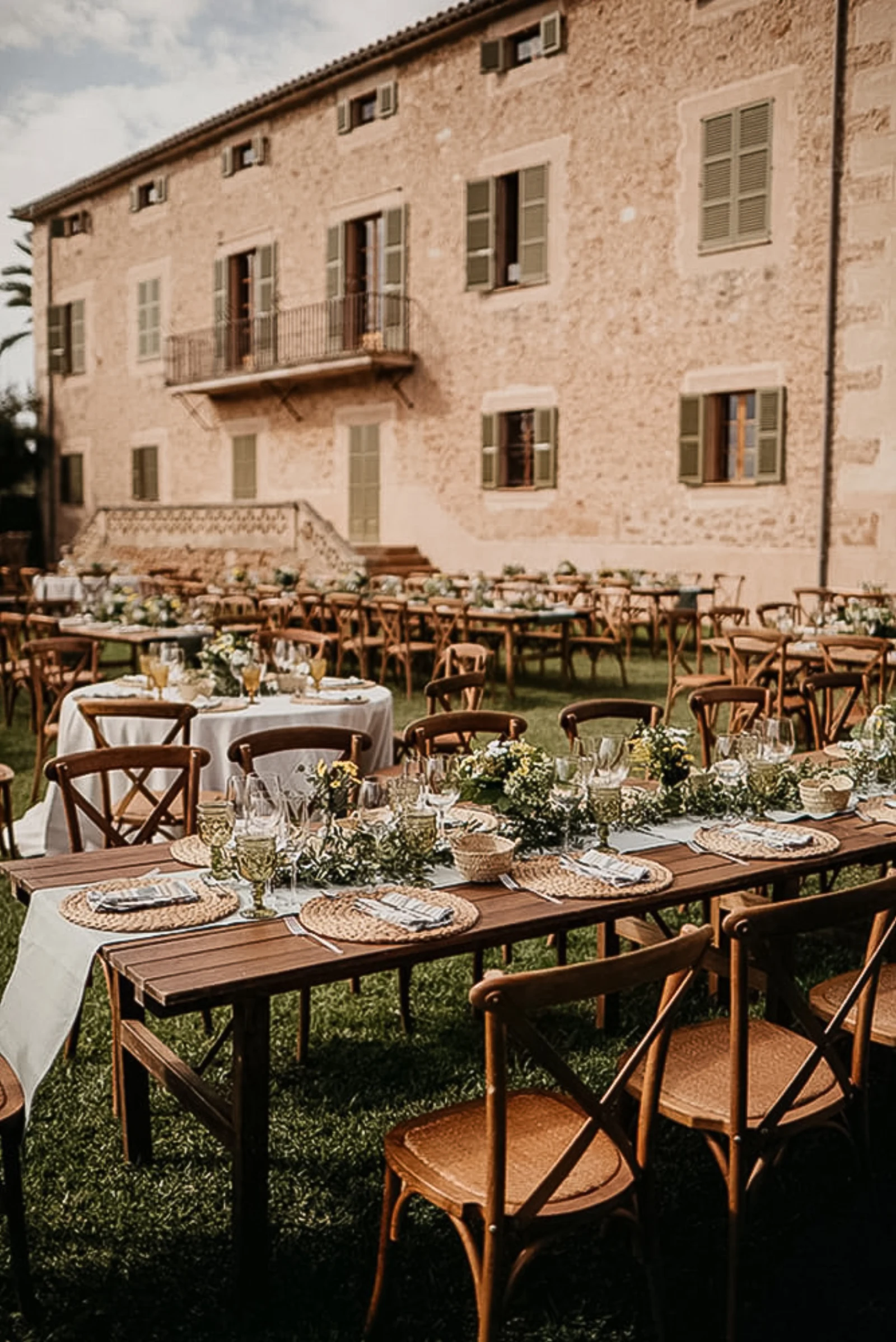 Rustikal gedeckte Hochzeitstafel vor einer Finca aus Naturstein auf Mallorca